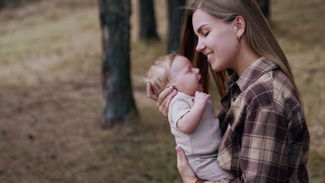loving mom puts her baby close to her chest. caucasian woman with her child outdoors in autumn. blurred backdrop.