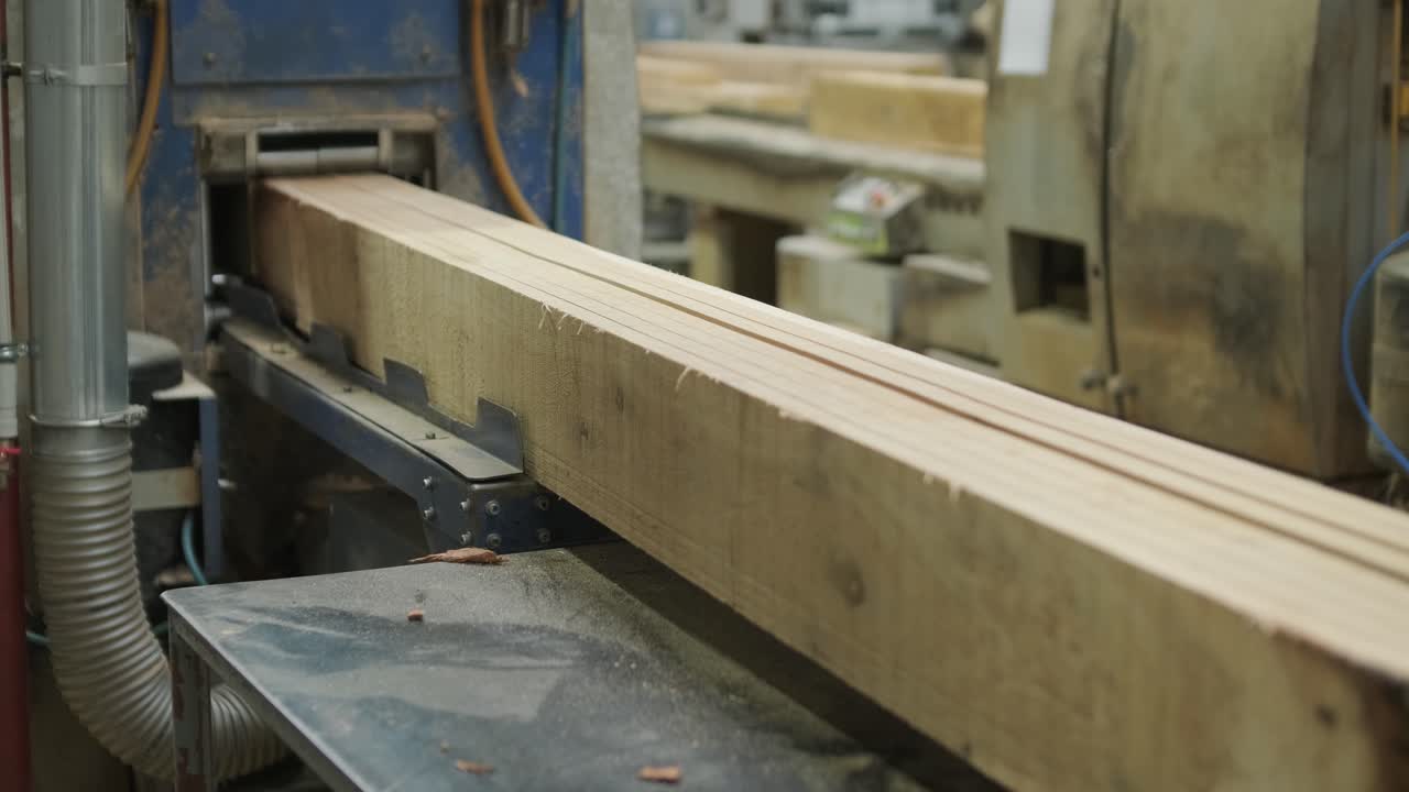Grande trave di legno lavorata da una macchina da taglio industriale in segheria