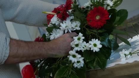 Florist-puts-a-white-flower-into-a-flower-arrangement