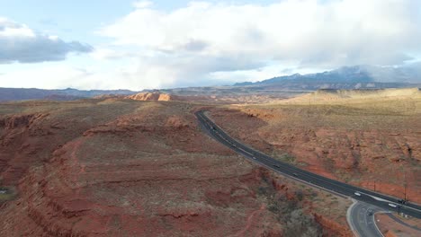 Hermosa-Vista-Aérea-Escénica-Del-Terreno-Rocoso-Rojo-De-Utah-Con-Vehículos-En-La-Carretera