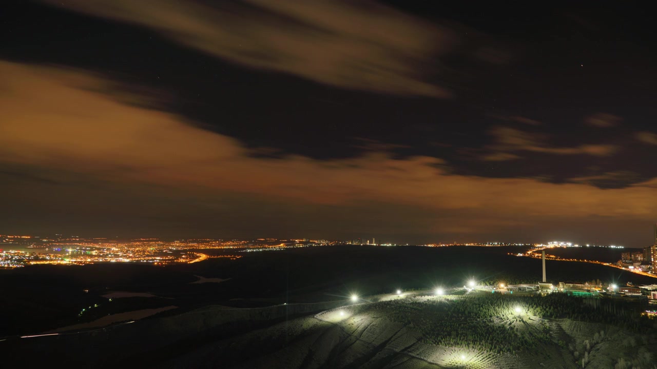 Lapso de tiempo de luces de la ciudad y nubes en movimiento de noche