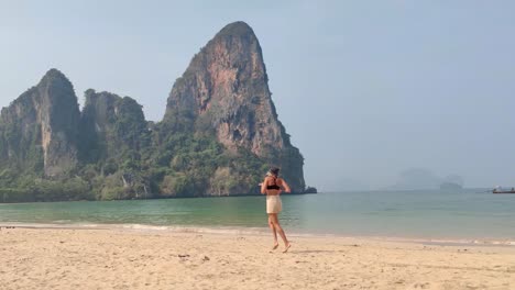 happy girl dancing on railay beach, thailand.
