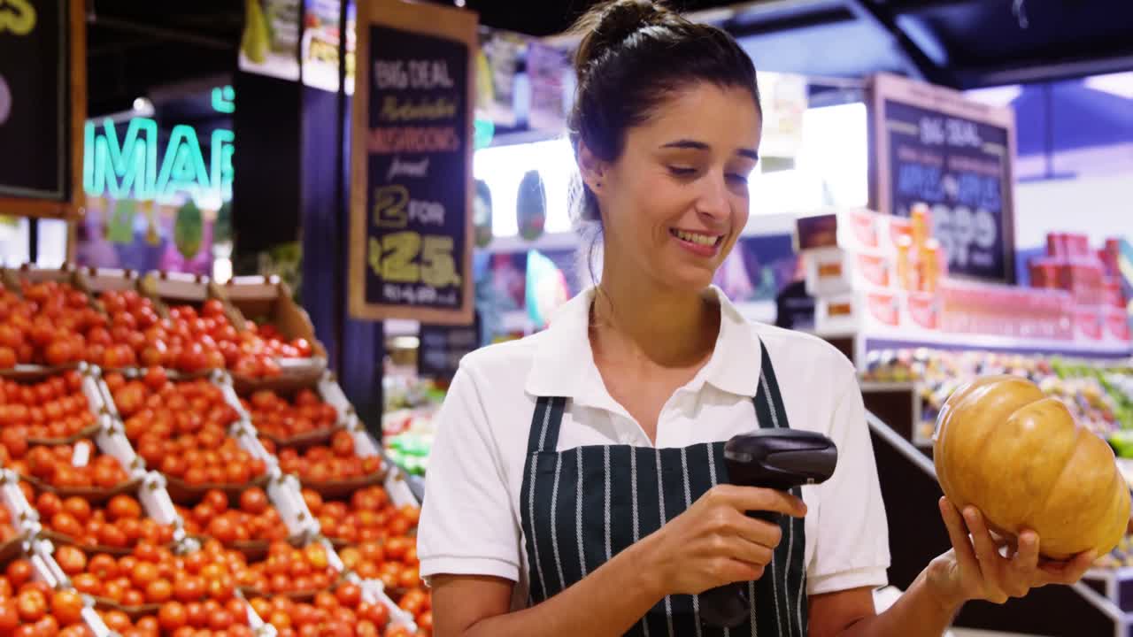 personal femenino escaneando calabaza con escáner de códigos de barras