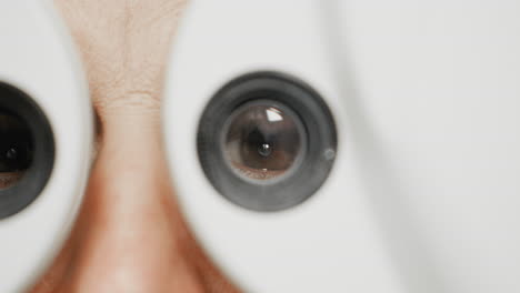 close up of female woman eyes looking through vision testing equipment selecting test results from eyes contact lenses prescription optician optometrist pupil of human brown eye doctor helping surgery