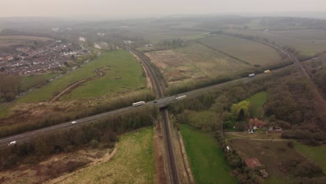 4K-Drohnenaufnahmen,-Die-In-Canterbury-Auf-Die-Zweispurige-A2-Zufliegen,-Während-Sie-über-Hambrook-Sümpfe-Und-Eine-Eisenbahnstrecke-Führt