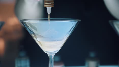 hair salon colorist mixing dye in fancy martini glass with customer watching