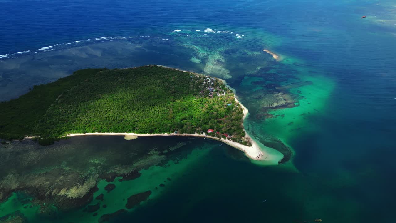 Detailní záběr z nízko letícího dronu podél pobřeží ostrova Magalawa zachycující vlny, textury písku a živou tropickou zeleň