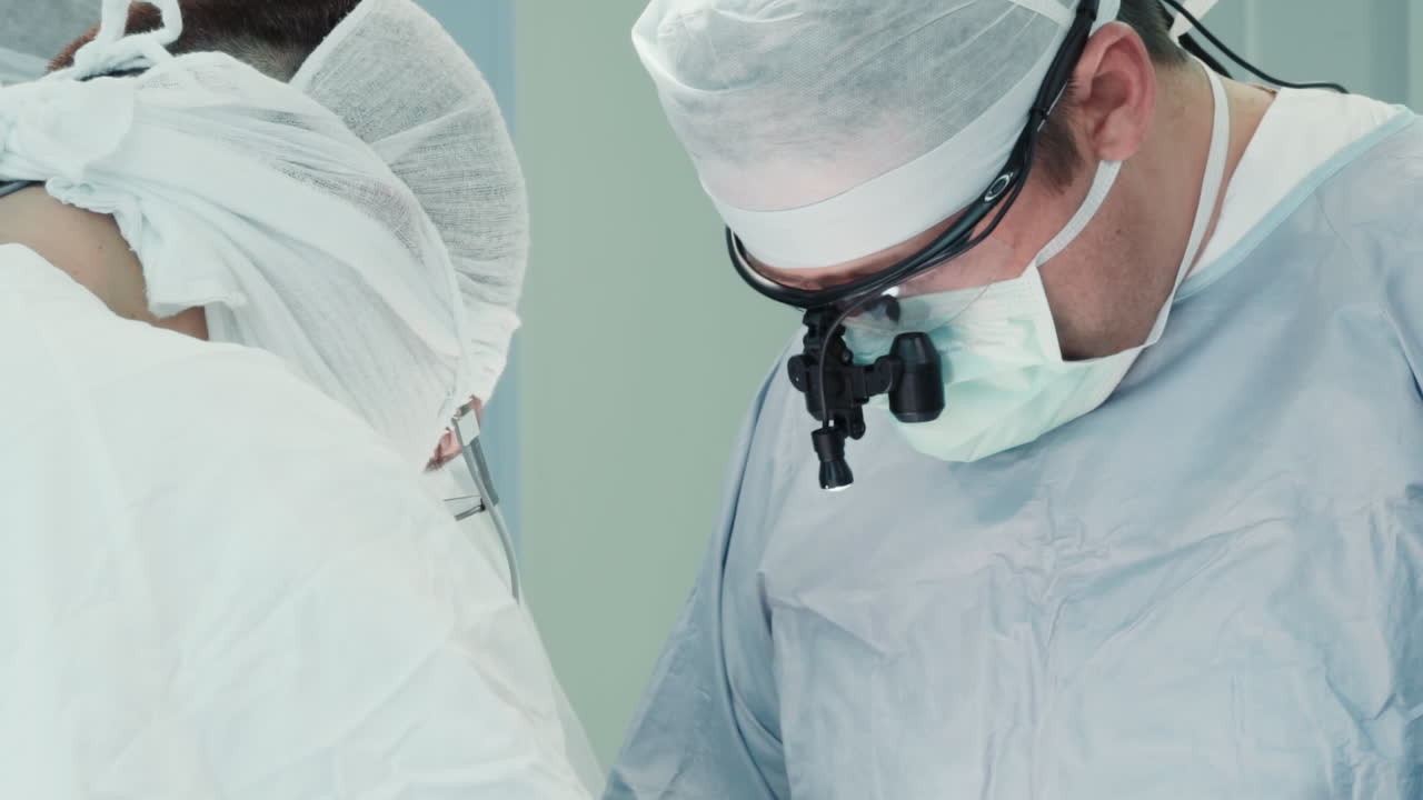 조수와 함께 수술을 수행하는 외과 의사. 비독성 유니폼과 전문 장비를 입은 수술팀이 수술실에서 관상동맥 질환을 치료합니다.