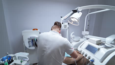 tooth treatment in a modern stomatology clinics. male dental care professionals uses tools and equipment treating the patient.