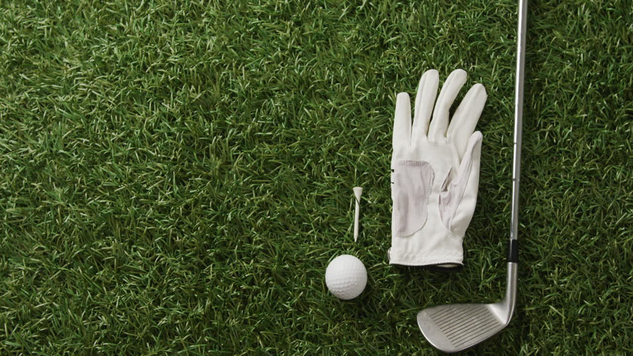 Close-up de taco de golfe, bola e luva na grama, espaço para texto, em câmera lenta