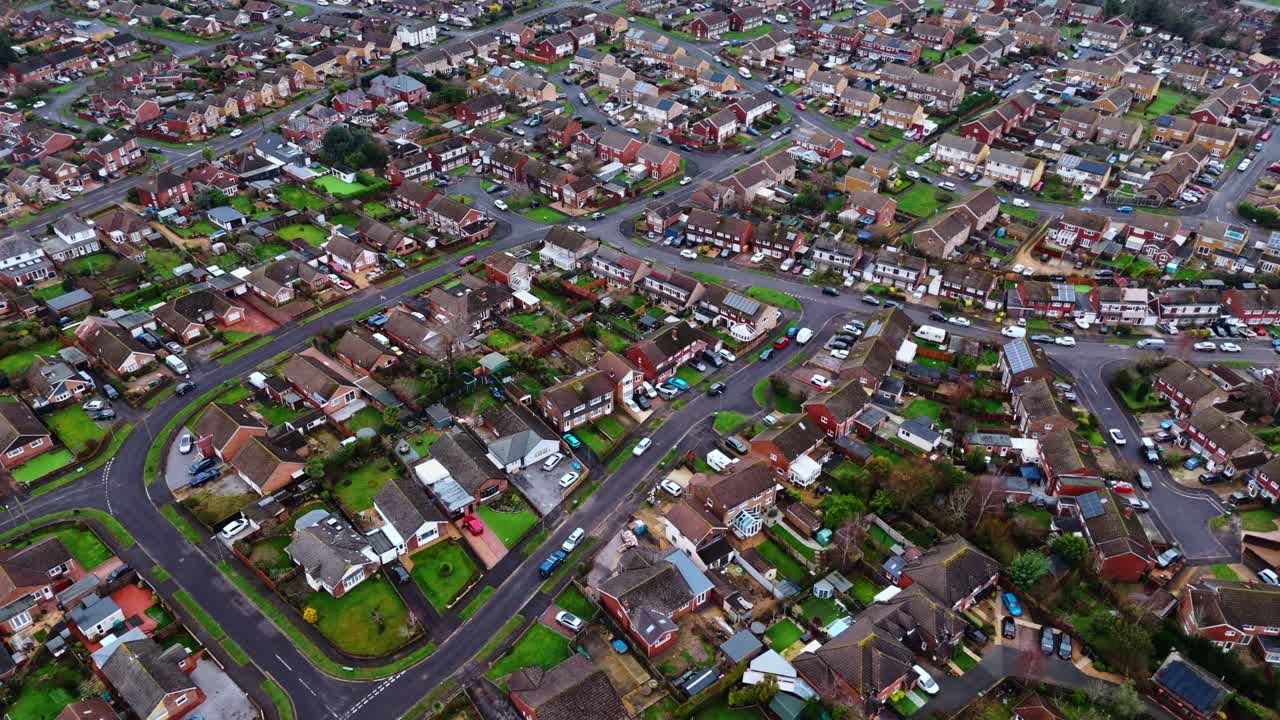 Panoramisk droneoptagelse fra luften over et forstadskvarter i Southampton, Hampshire, ved navn Hedge End. Optaget ved en stille solnedgang på en overskyet vinterdag med mange huse, marker og biler på vejene nedenfor.