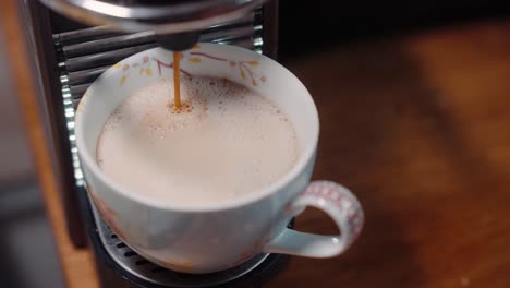 espresso goteando en la taza y luego recogido en cámara lenta 4k 30fps