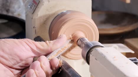 cutting wood on a lathe with a chisel