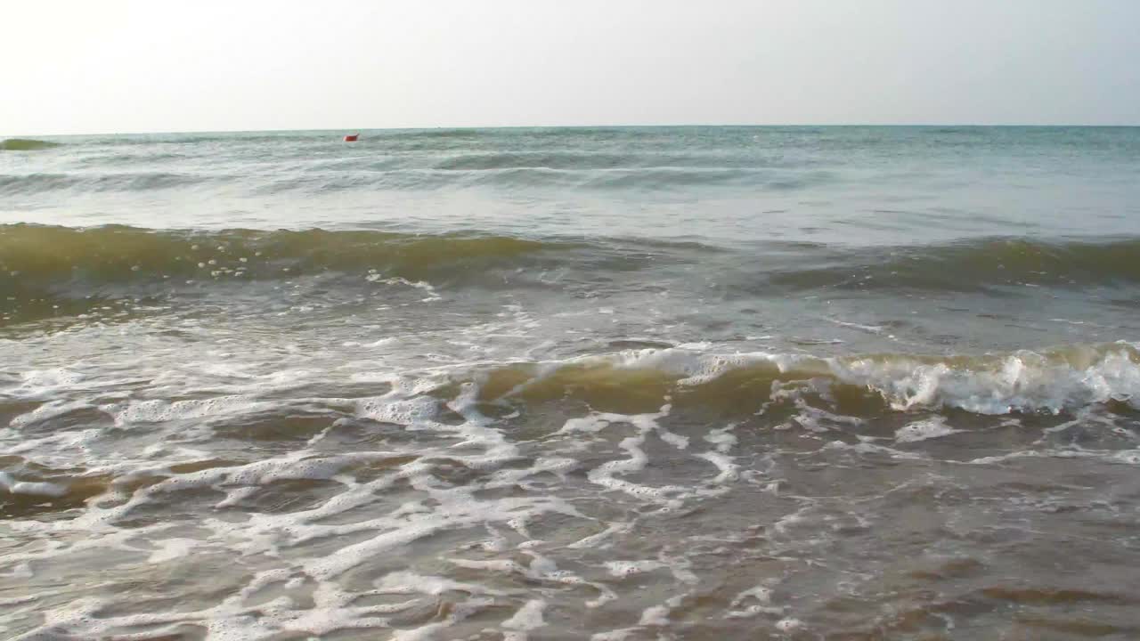 푸른 하늘 모래사장에 작은 파도가 밀려온다