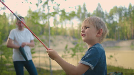 The-boy-helps-his-father-to-set-up-and-assemble-a-tent-in-the-forest.-Teaching-children-and-travelling-together-in-a-tent-camp