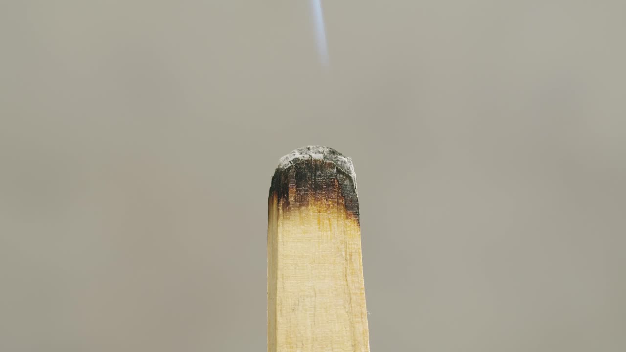Person holding Palo Santo wood stick in hand, aromatic Palo Santo burning on black background, smoke spreading around, slow motion video clip, high quality 4k close up footage. High quality 4k footage