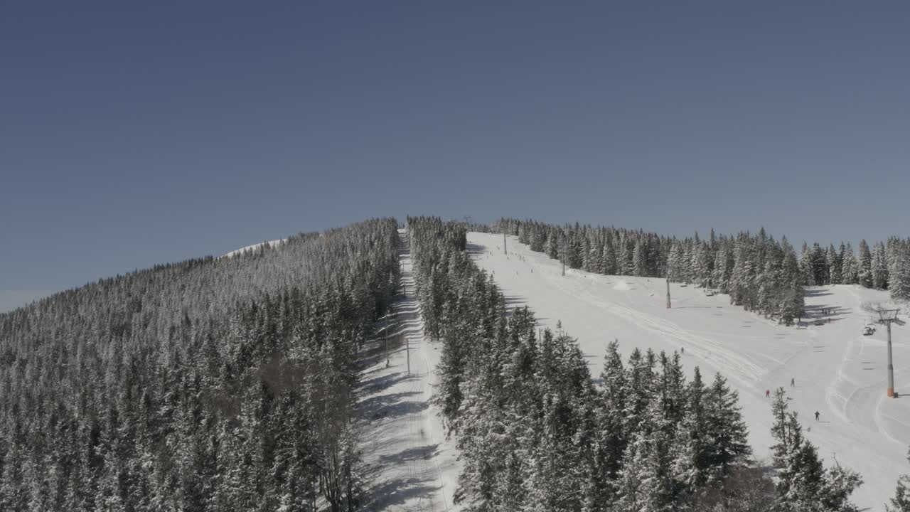 Slovenya'daki Kope kış tatil köyünde, açık bir günde kayak telesiyeji ve Ribnica pisti, Havadan yükselen çekim.