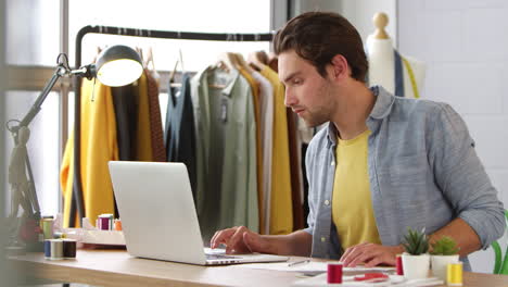 male student or business owner working in fashion using laptop in studio