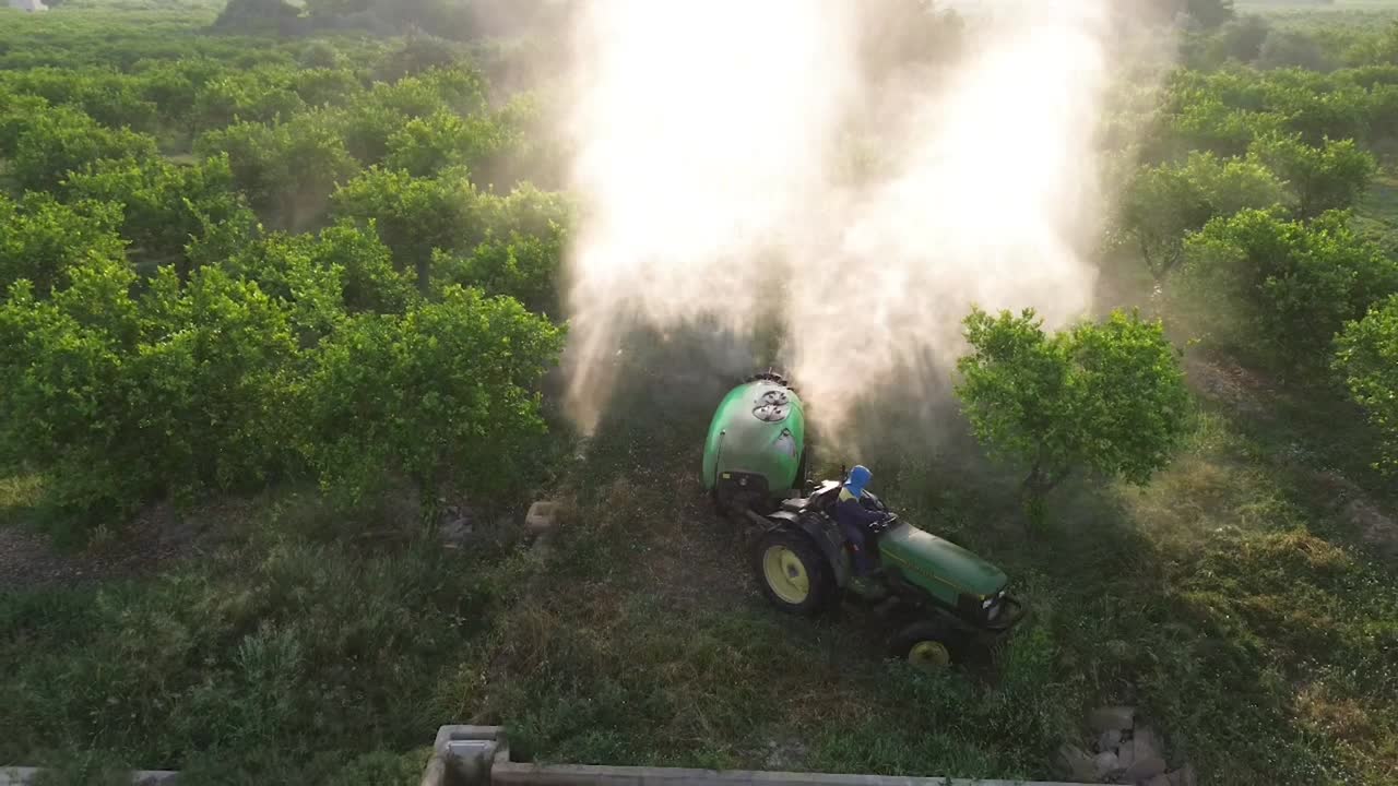 Tractor spraying pesticide drone aerial view, pesticides or insecticide spray on lettuce or iceberg field. Pesticides and insecticides on agricultural field in Spain
