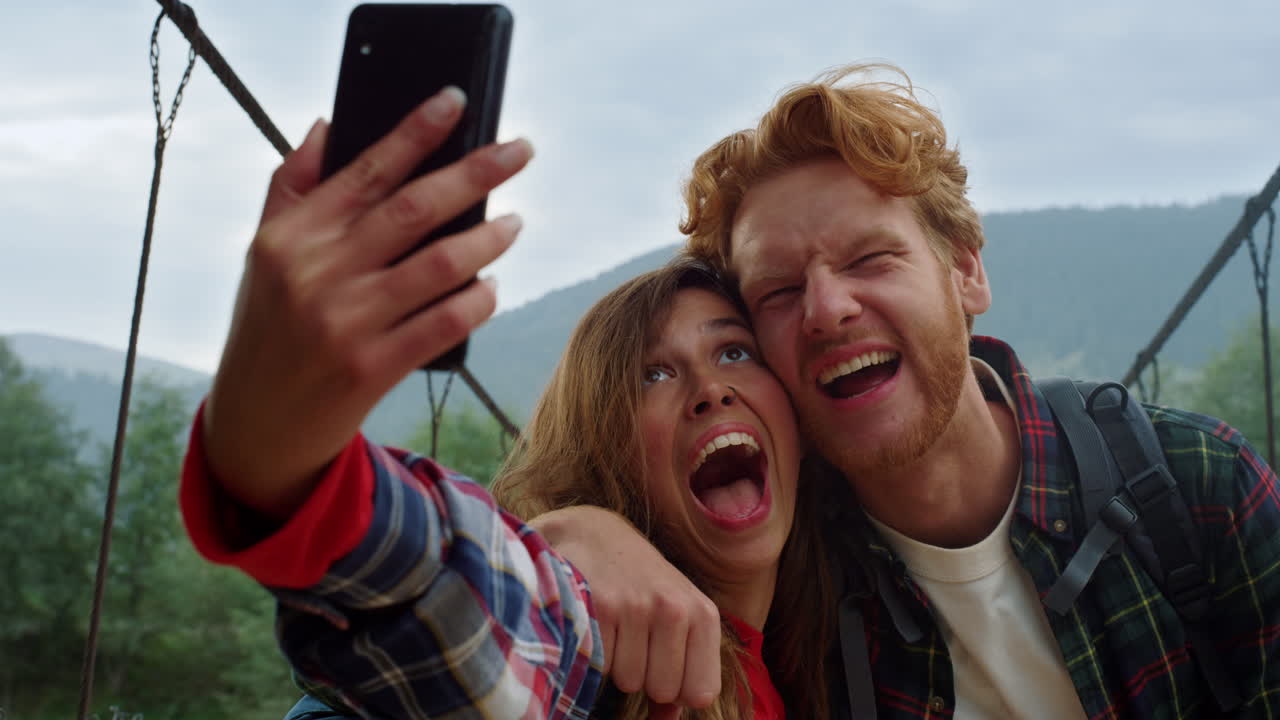 pareja feliz tomando fotos en el teléfono móvil. amigos disfrutan de viajar en las montañas.