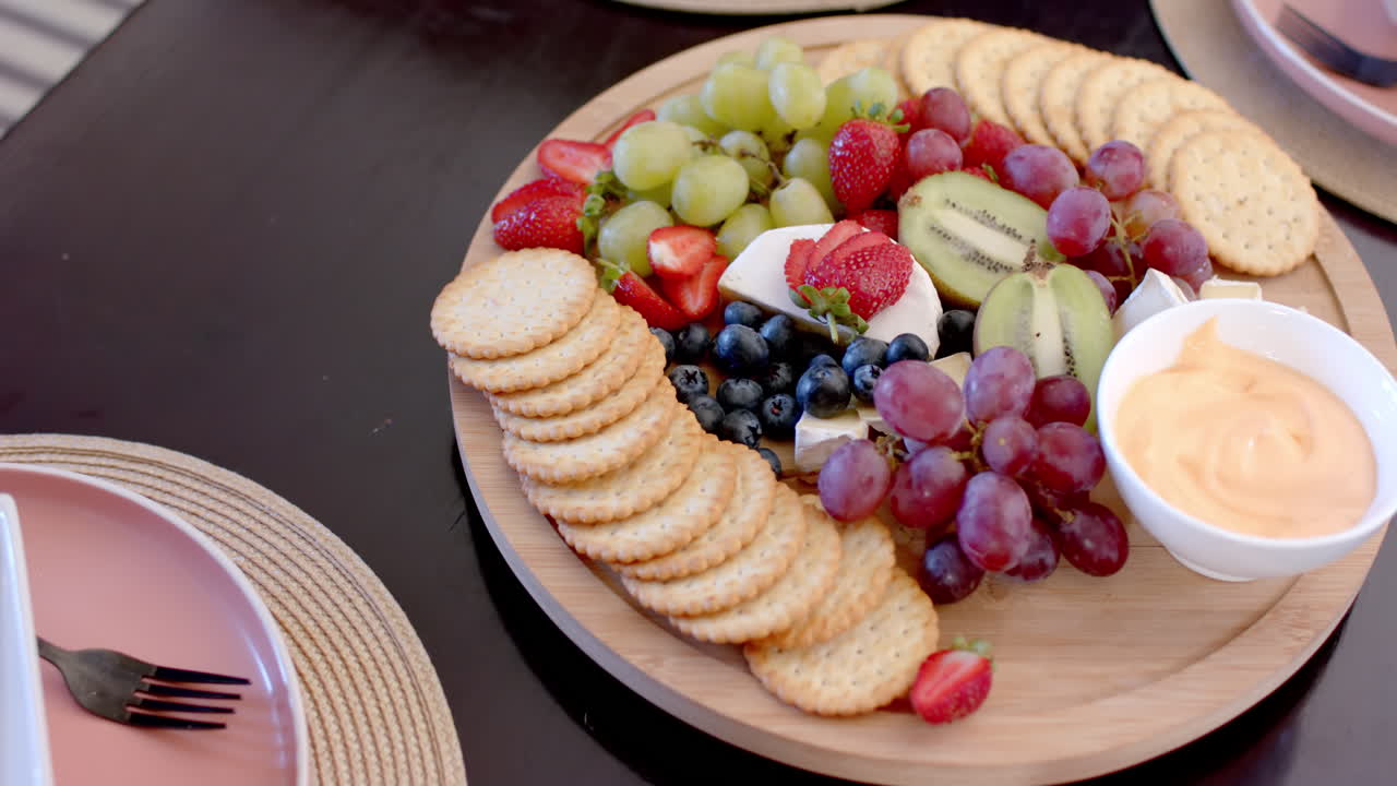 Serving platter of assorted fruits, cheese, and crackers for gathering