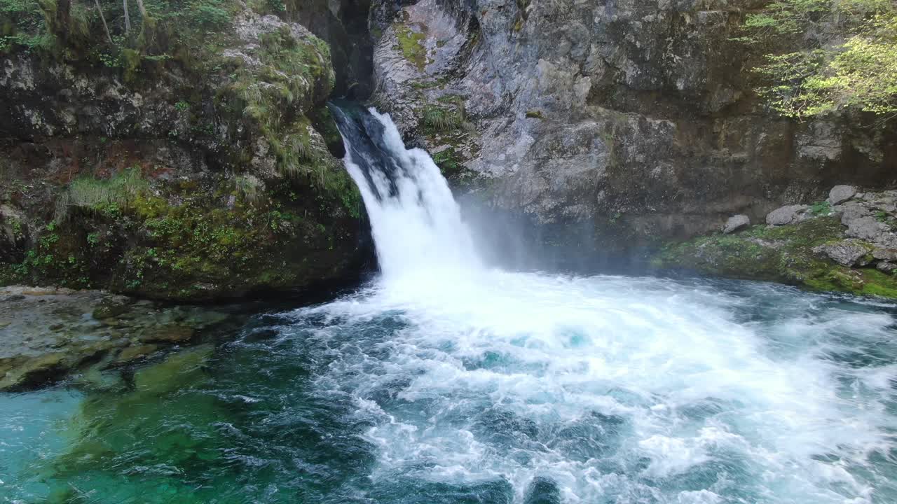 Drone view in Albania in the alps flying in front of a waterfall surrounded by the rocky and green mountain in Theth