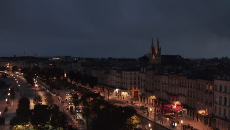 Bordeaux-at-Night-with-view-of-Saint-Louis-des-Chartrons-Church,-slow-establishing-Aerial