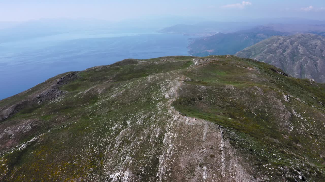 Ripresa aerea all'indietro di alte montagne rocciose vicino al mare, Parco Nazionale di Galičica