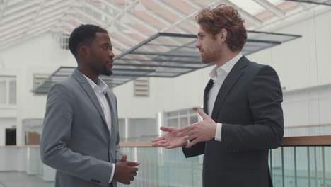 two diverse businessmen talking in hall