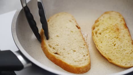 persona anónima fritando rebanadas de pan en una sartén