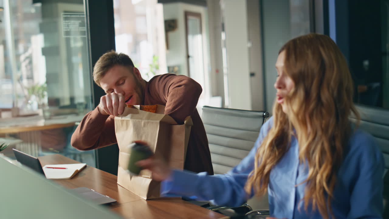 Friendly woman bringing coffee to man coworker in office. Happy manager surprise