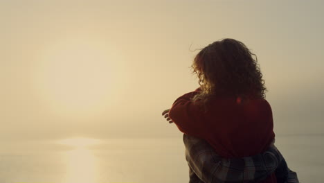 woman and man dancing on beach at sunrise. romantic couple hugging at sea shore