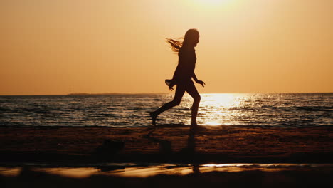 silhouette of a carefree child running along the beach