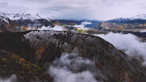 dusted snow and moody fog hovering over a remote scene filled with fall colors in colorado