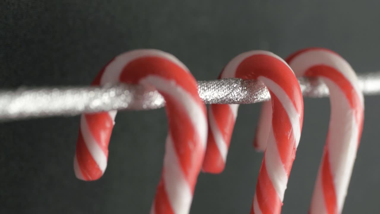 Three candy canes hanging on a wire close up