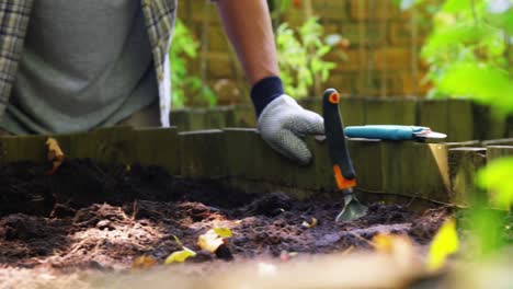 Senior-man-digging-in-the-soil-with-shovel