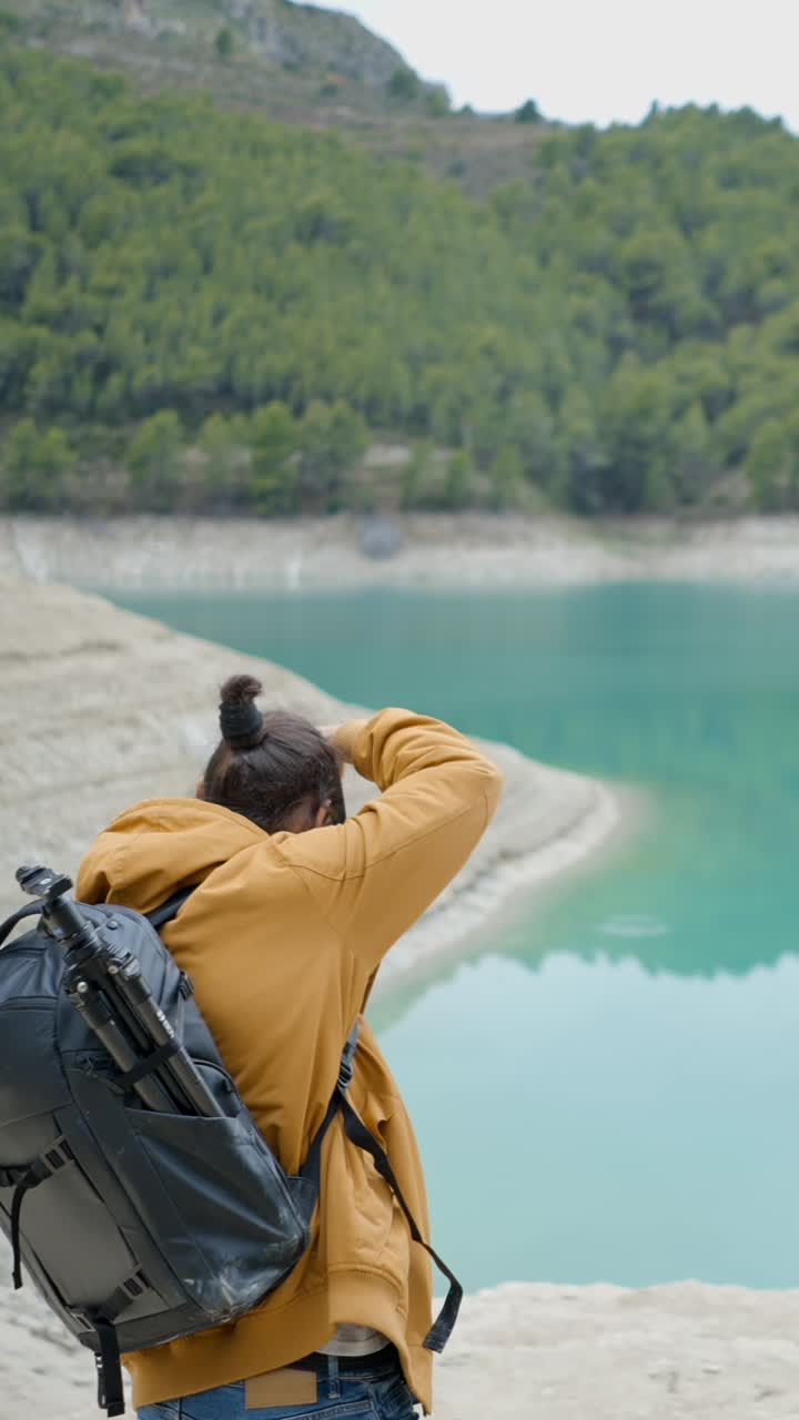 Photographer capturing scenic lake and mountain landscape