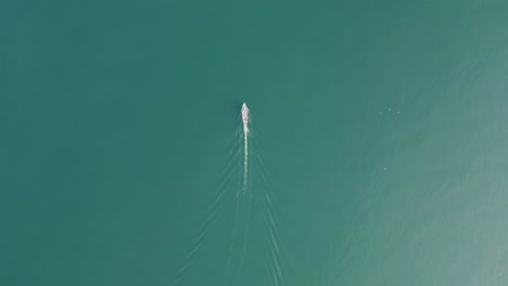 vista aérea de un barco navegando en las tranquilas aguas azules del lago garda en italia