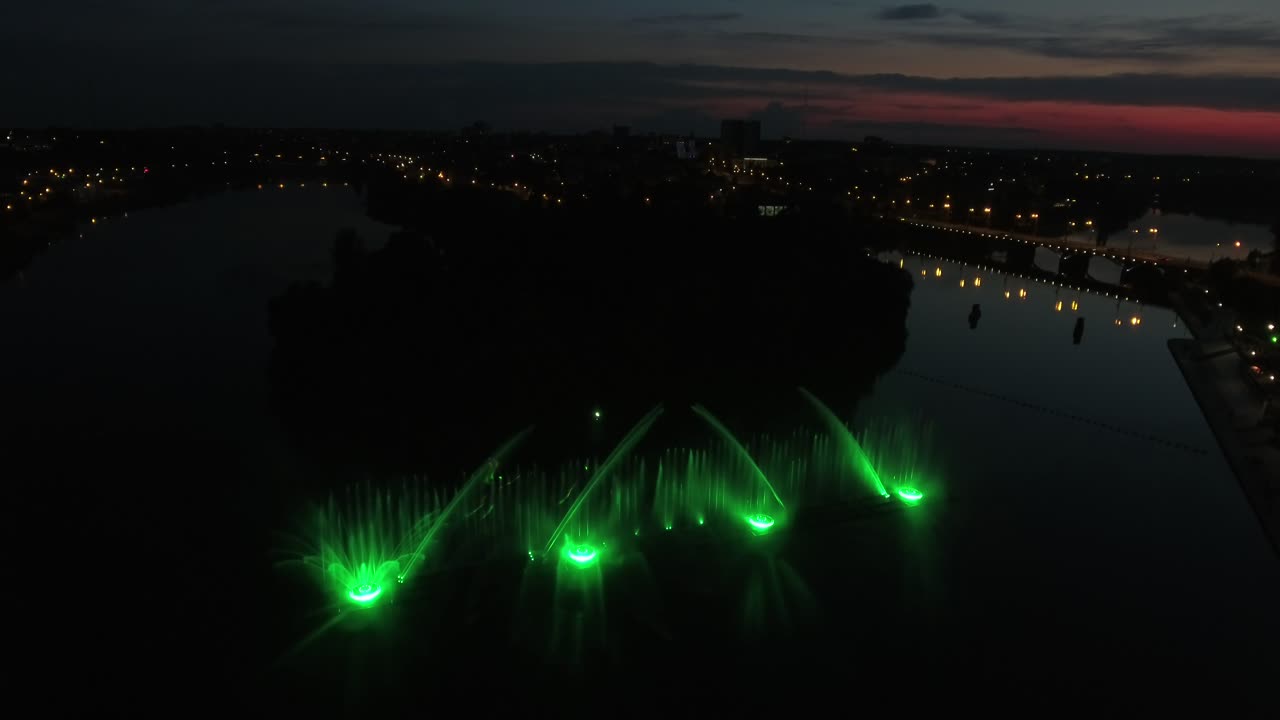 Fountain With Colorful Illuminations At Night. Aerial shot of the magic fountain - lights,colors and music spectacle at night