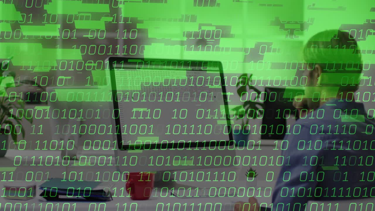 Worker resting chin watching green binary digits flooding monitor and spilling onto desk in tech