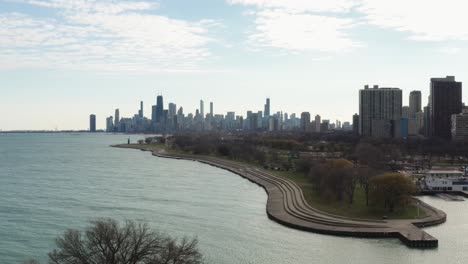 aerial lakeside view of belmont rocks with chevron sculpture on the left and chicago downtown in the background in autumn