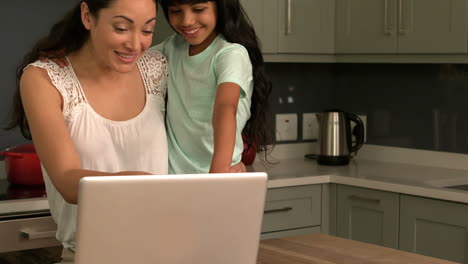 Feliz-Madre-E-Hija-Usando-Una-Computadora-Portátil-En-La-Cocina