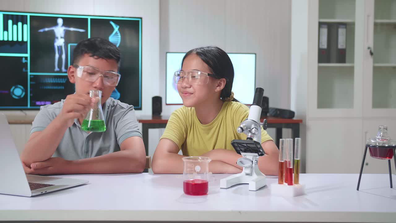 Young Asian Boy And Girl Learning Science Experiment In Laboratory At Classroom. Study With Scientific Equipment And Test Tubes