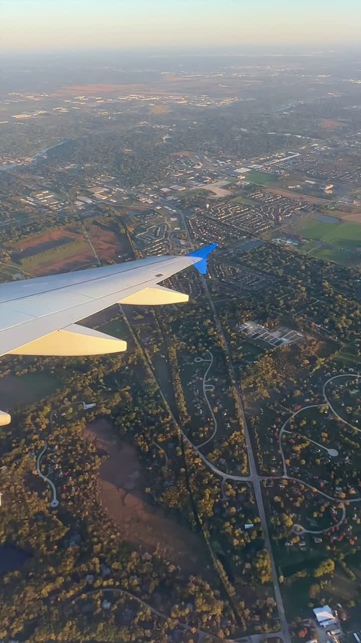 En flyvinge glider over et udstrakt forstadsområde, der fanger det detaljerede netværk af veje og kvarterer. Perfekt til rejserelateret indhold eller visualiseringer af byplanlægning.