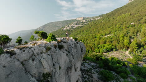 adventurer stands at white cliff edge as drone pullsback on lubenice cres croatia