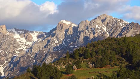 Mountain-ridge-with-trees-under-cloudy-sky