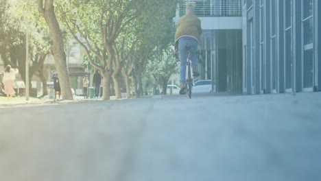 spots of light against rear view of a man riding a bicycle on the street