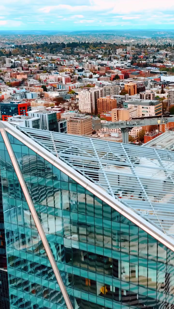 Volando sopra le cime di incredibili grattacieli nel centro della città. Immenso paesaggio urbano con un lago sullo sfondo. Seattle, Washington, Stati Uniti. Video verticale