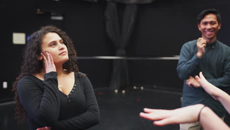 teacher with drama students at performing arts school in studio improvisation class