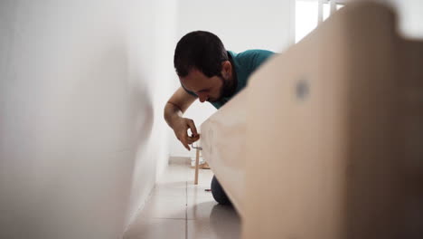 hispanic adult assembling a house bed using allen key tool